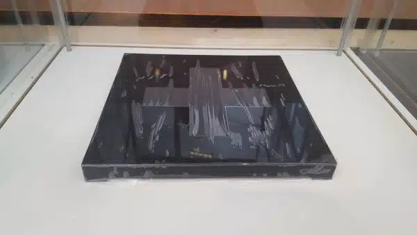 Clear glass display with black base and reflections.