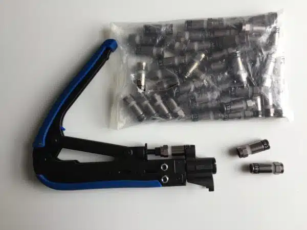Crimping tool with cable connectors on white background.