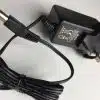 Black laptop charger with European plug on white background.