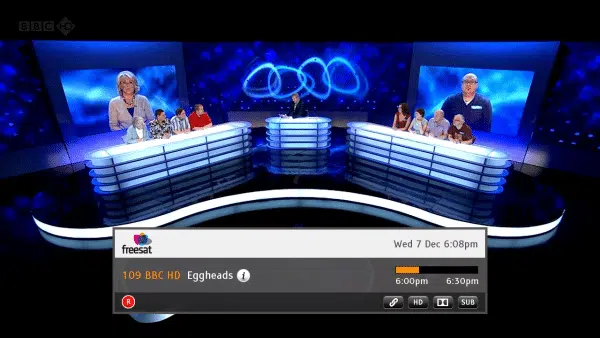 Quiz show "Eggheads" on TV with contestants and host.