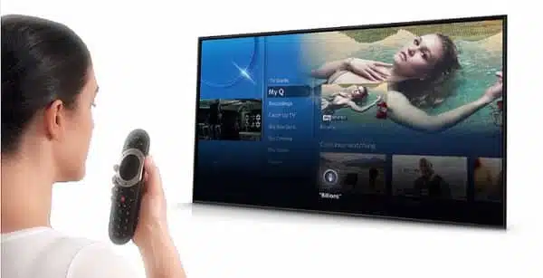 Woman using remote to navigate smart TV interface.
