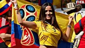 Football fan holding Colombian flag at FIFA event.