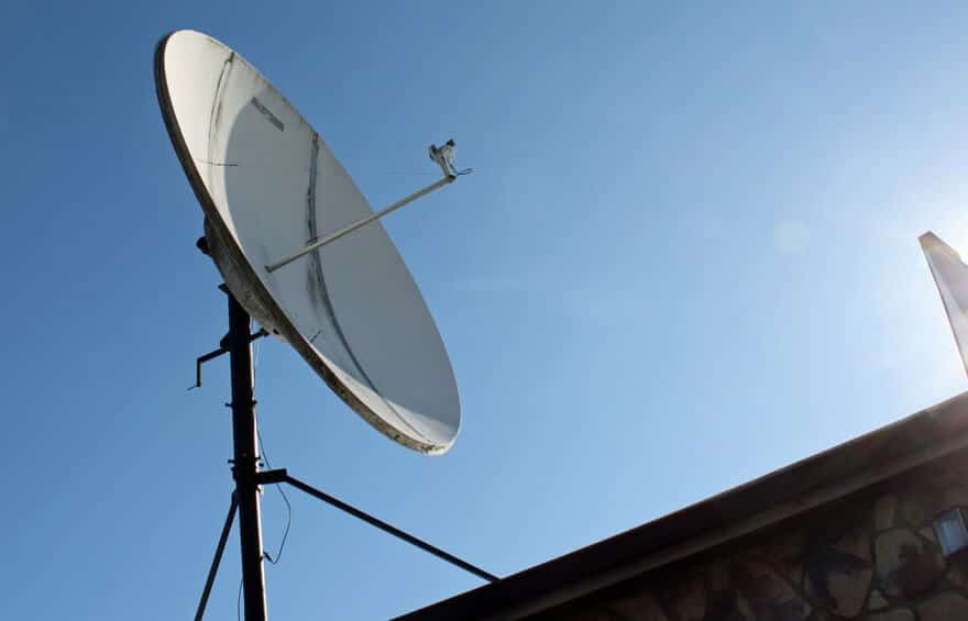Satellite dish against clear blue sky.