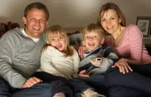 Family smiling together on couch at home