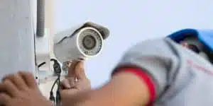 Technician installing outdoor security camera.